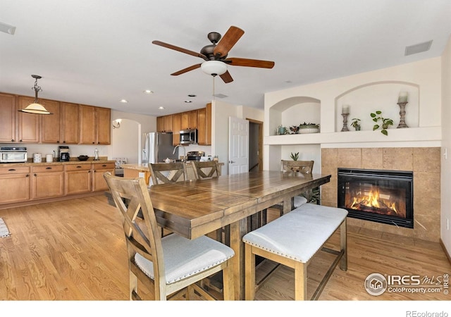 dining room with a fireplace, recessed lighting, light wood-style floors, and visible vents