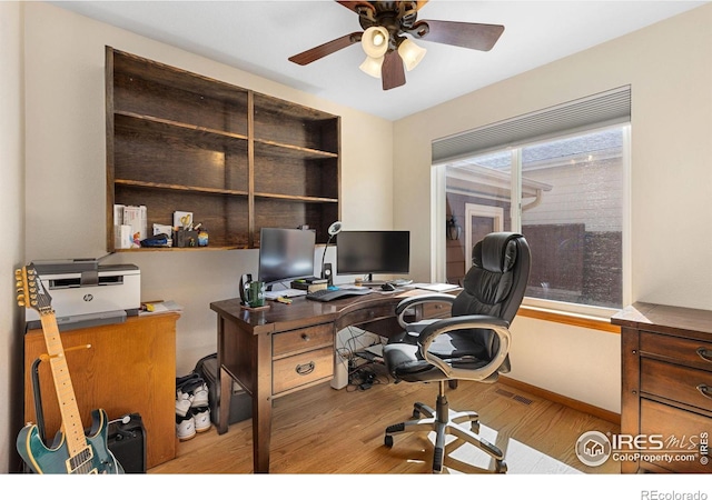 office space featuring visible vents, baseboards, ceiling fan, and wood finished floors