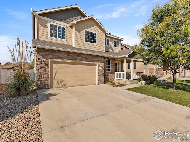 view of front of home with an attached garage, fence, covered porch, stone siding, and driveway