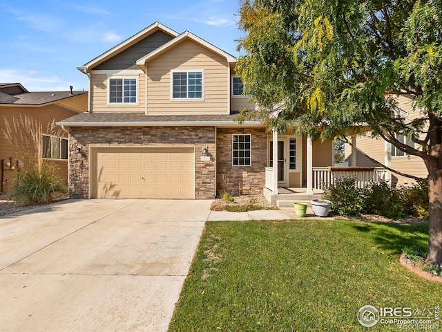 view of front of house featuring a front lawn, stone siding, covered porch, and driveway