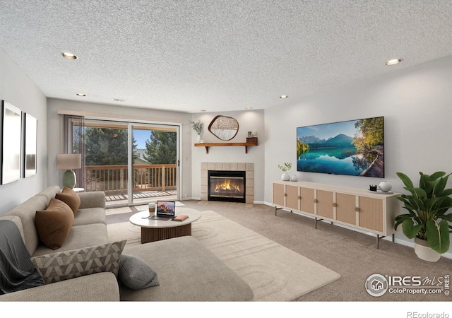 living area with a tiled fireplace, a textured ceiling, recessed lighting, carpet, and baseboards