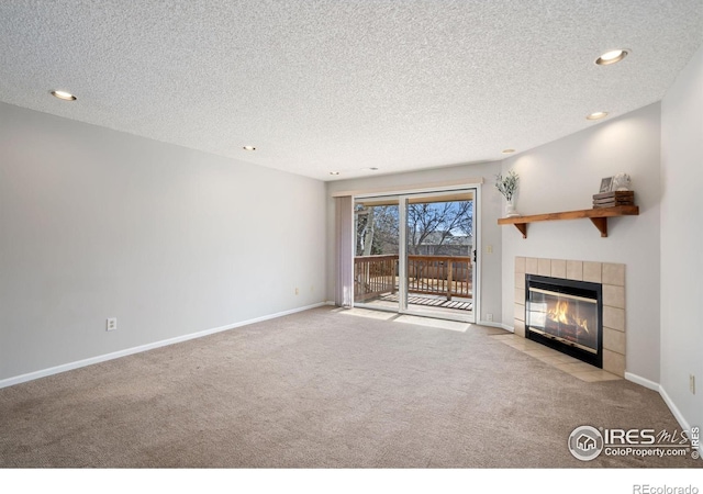 unfurnished living room featuring a fireplace, baseboards, carpet floors, and a textured ceiling