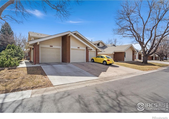 view of front of house featuring a garage, brick siding, and concrete driveway