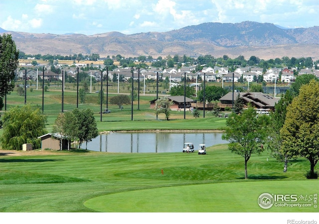 view of home's community with a yard, a water and mountain view, a residential view, and golf course view