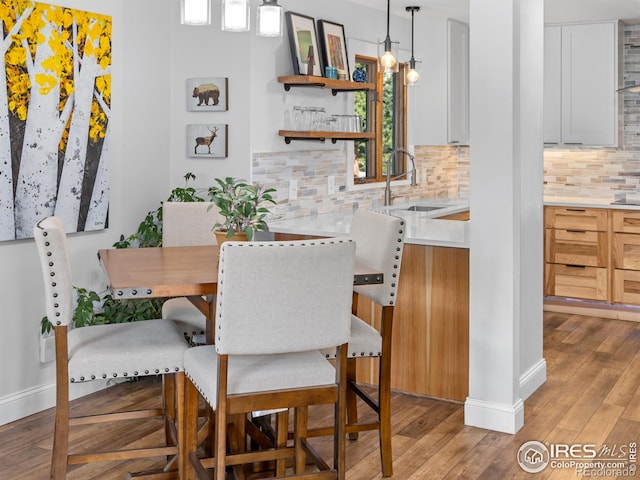 dining space with light wood-style flooring and baseboards