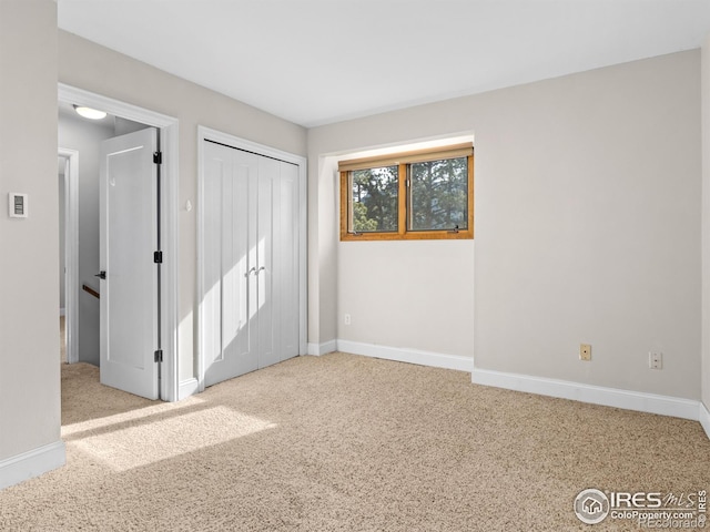 unfurnished bedroom featuring a closet, baseboards, and carpet flooring