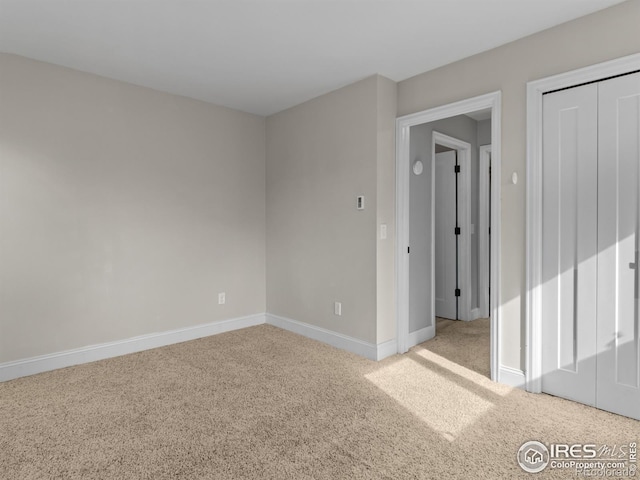 unfurnished room with carpet flooring and baseboards