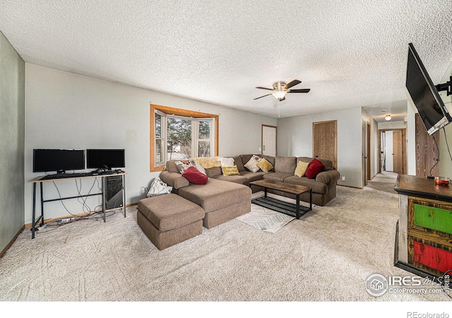 living room featuring a textured ceiling, carpet flooring, baseboards, and ceiling fan