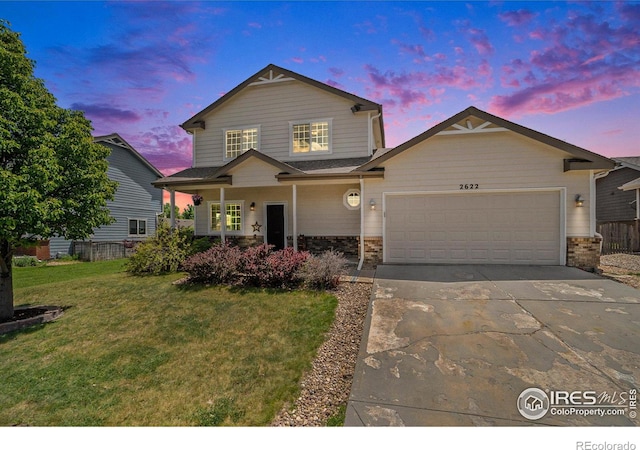 traditional-style home with a front lawn, an attached garage, brick siding, and driveway