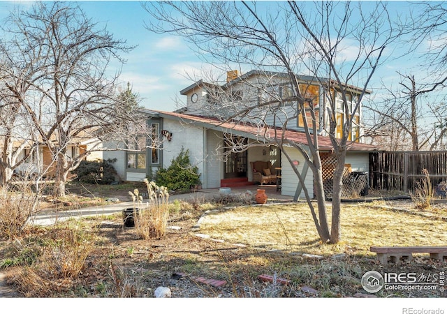 view of front of home featuring brick siding and fence