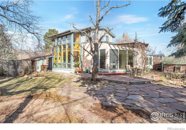 back of property with a patio and a sunroom