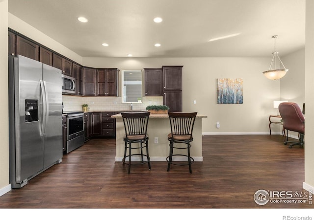 3948 Hackberry St, Wellington, CO 80549 - kitchen featuring stainless steel appliances, tasteful backsplash, dark brown cabinetry, and dark wood finished floors