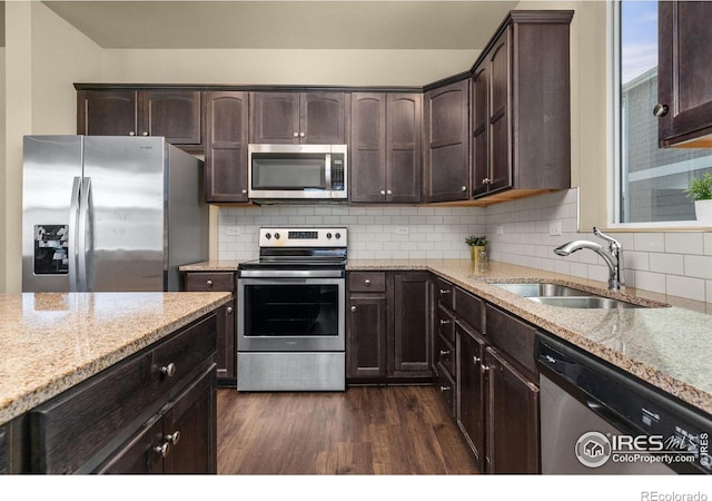 3948 Hackberry St, Wellington, CO 80549 - kitchen featuring light stone counters, a sink, dark wood-type flooring, dark brown cabinets, and appliances with stainless steel finishes