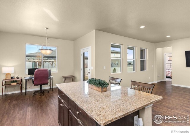 3948 Hackberry St, Wellington, CO 80549 - kitchen with decorative light fixtures, dark wood-style floors, baseboards, dark brown cabinets, and light stone countertops