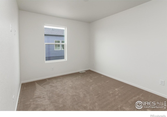 carpeted empty room featuring visible vents and baseboards