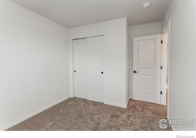 unfurnished bedroom featuring a closet, visible vents, baseboards, and carpet