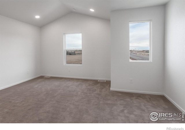 unfurnished room featuring baseboards, visible vents, carpet floors, and lofted ceiling