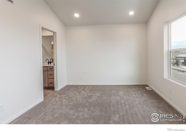 empty room featuring recessed lighting, carpet flooring, baseboards, and visible vents