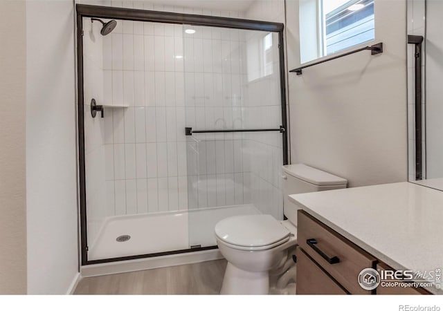 bathroom with vanity, a shower stall, and toilet