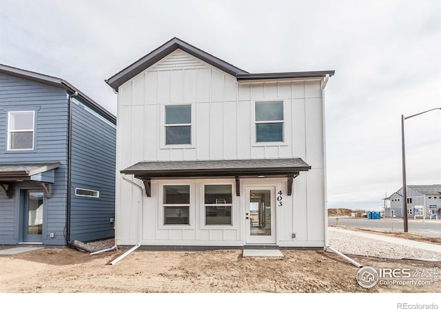 modern inspired farmhouse with board and batten siding and a shingled roof