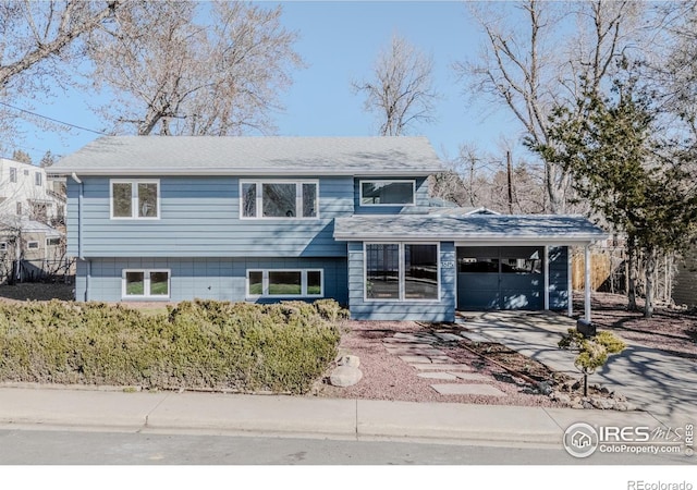 split level home with concrete driveway and a garage