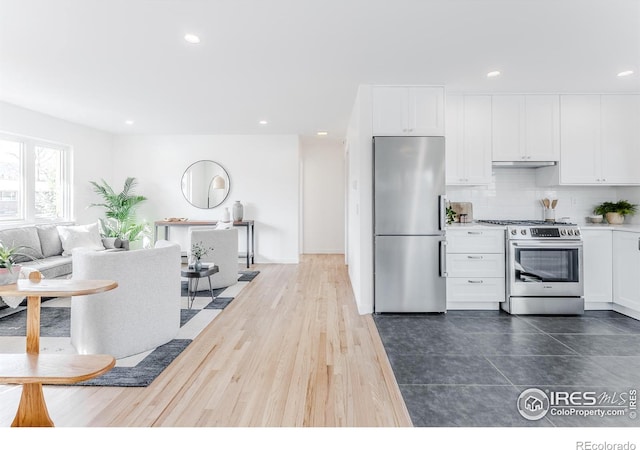 kitchen featuring recessed lighting, stainless steel appliances, decorative backsplash, under cabinet range hood, and white cabinetry