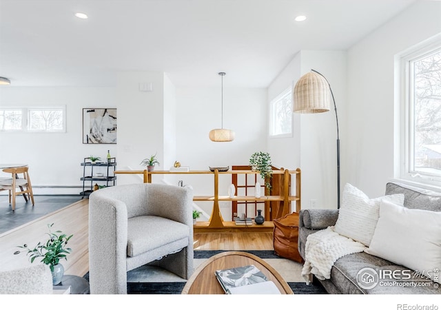 living room with recessed lighting, wood finished floors, and a baseboard radiator