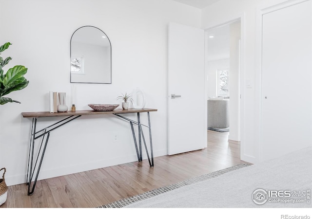 hall featuring baseboards and wood finished floors