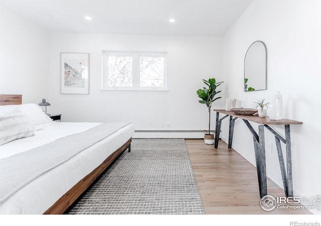 bedroom featuring recessed lighting, wood finished floors, and a baseboard radiator