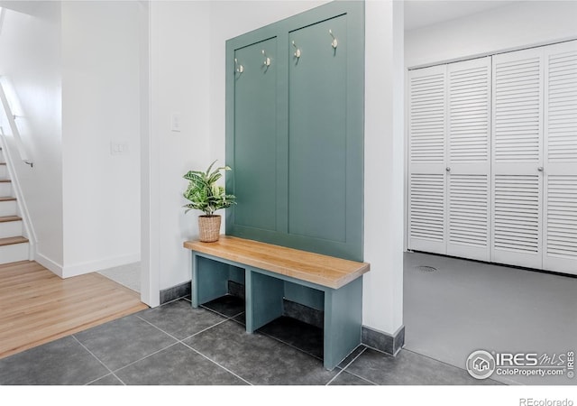 mudroom with baseboards and dark tile patterned flooring