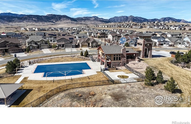 pool featuring a patio area, a residential view, a mountain view, and fence