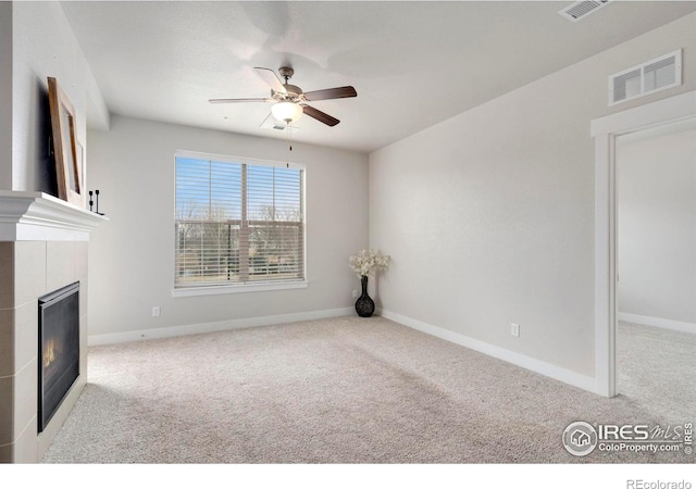 unfurnished living room featuring visible vents, baseboards, a glass covered fireplace, and carpet flooring