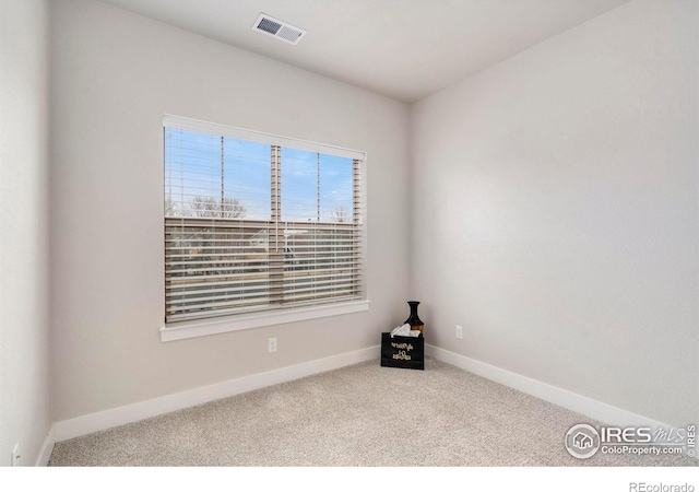 spare room with visible vents, carpet floors, and baseboards