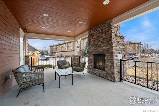 view of patio featuring an outdoor stone fireplace