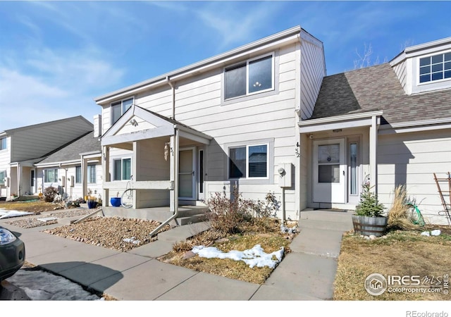 townhome / multi-family property featuring roof with shingles