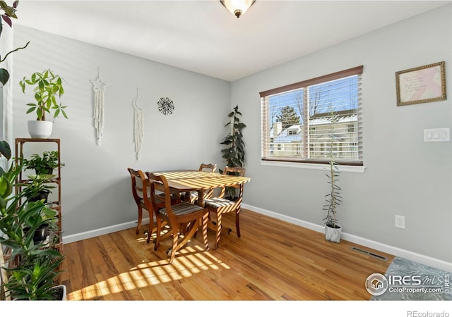 dining area with visible vents, baseboards, and wood finished floors