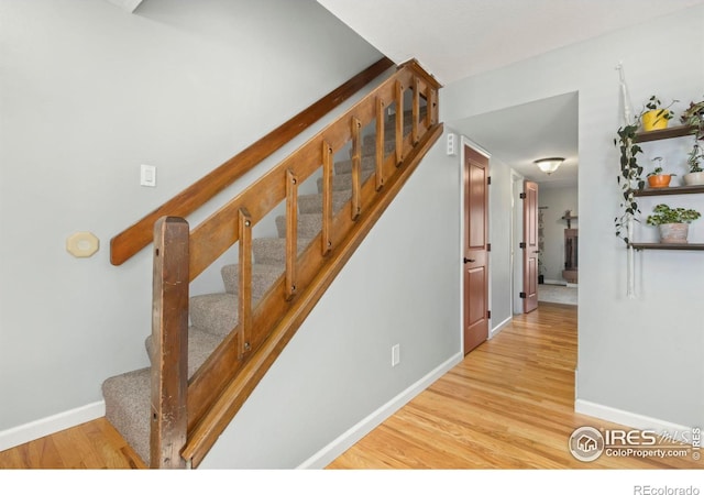 stairway with wood finished floors and baseboards