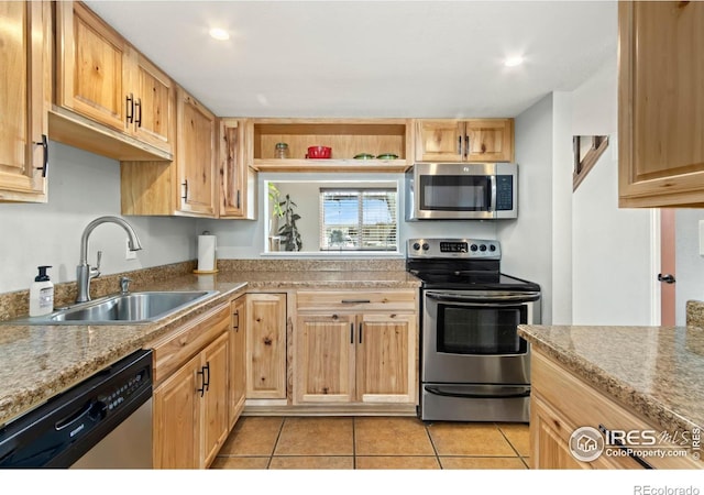 kitchen with light tile patterned floors, light brown cabinetry, a sink, light countertops, and appliances with stainless steel finishes