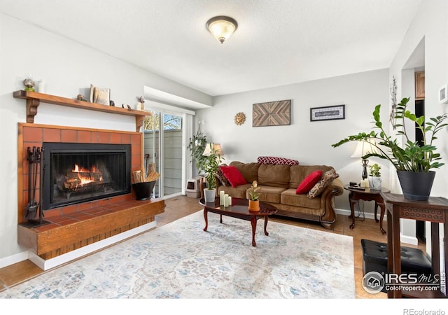 living area with tile patterned floors, baseboards, a textured ceiling, and a tile fireplace