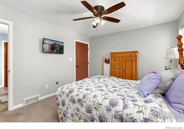 carpeted bedroom with visible vents, baseboards, and a ceiling fan