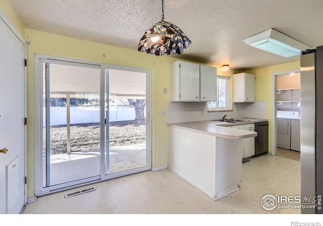 kitchen featuring tasteful backsplash, visible vents, dishwashing machine, a peninsula, and independent washer and dryer