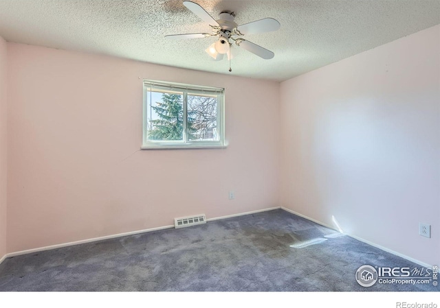 empty room featuring baseboards, visible vents, carpet floors, ceiling fan, and a textured ceiling