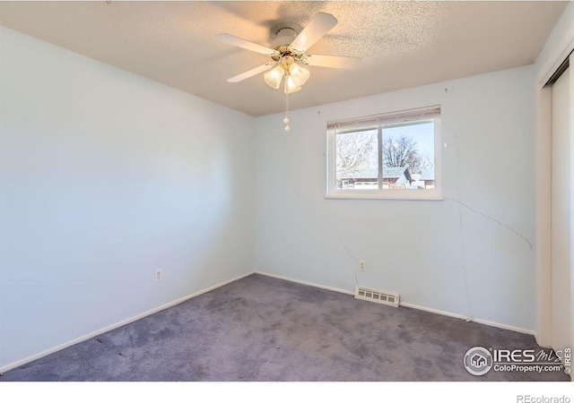 unfurnished room featuring visible vents, carpet floors, and a textured ceiling