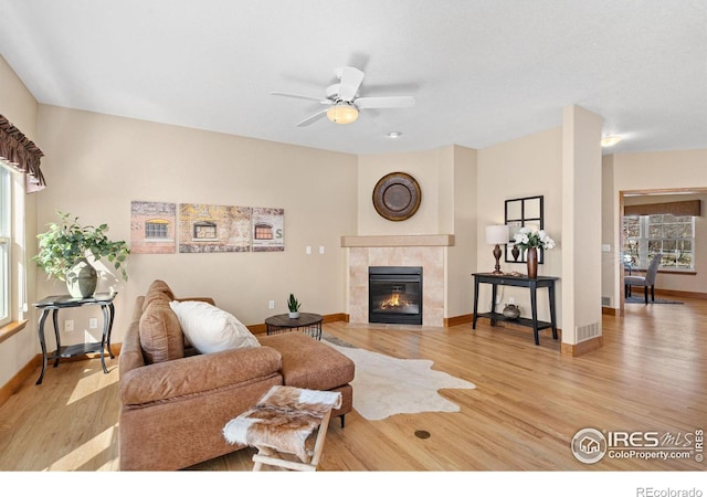 living area with a fireplace, wood finished floors, and baseboards