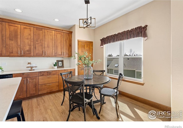 dining area featuring light wood-style flooring, recessed lighting, baseboards, and a chandelier