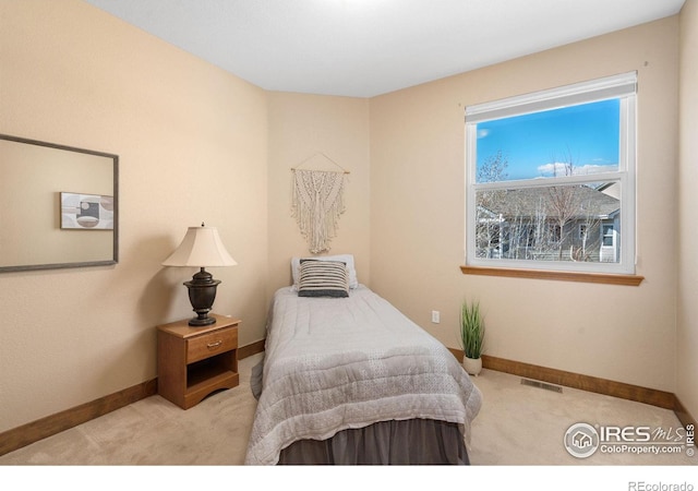 carpeted bedroom with visible vents and baseboards