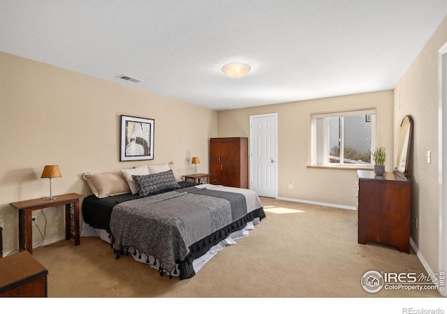 carpeted bedroom featuring visible vents and baseboards