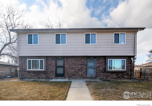 1327 Emery St, Longmont, CO 80501 - colonial inspired home with brick siding, a front lawn, and fence