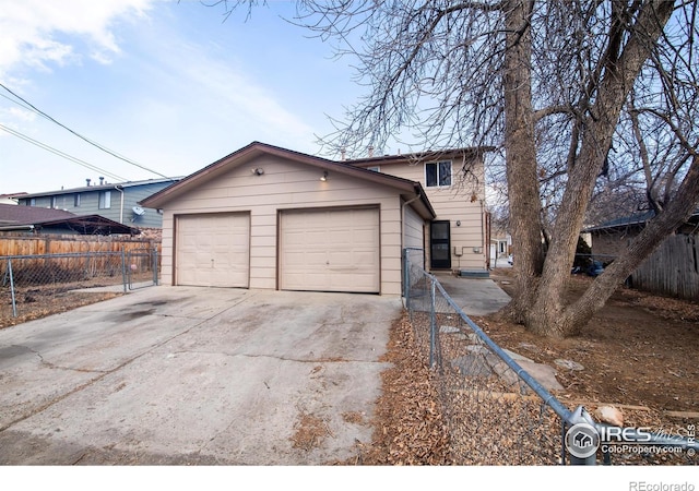 view of front of property with driveway, an outdoor structure, an attached garage, and fence