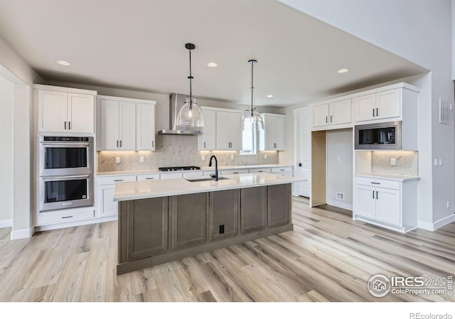 1685 Crystalline Dr, Windsor, CO 80550 - kitchen with white cabinets, wall chimney exhaust hood, a sink, light countertops, and appliances with stainless steel finishes